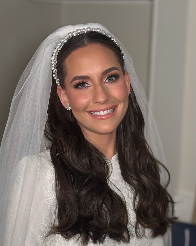 Smiling bride with a pearl headband and veil